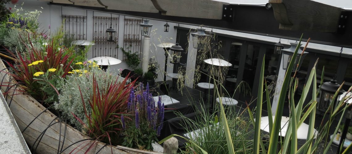 Decked out with herbs, citrus, and passion vines, restaurant patrons are surrounded by greenery.
